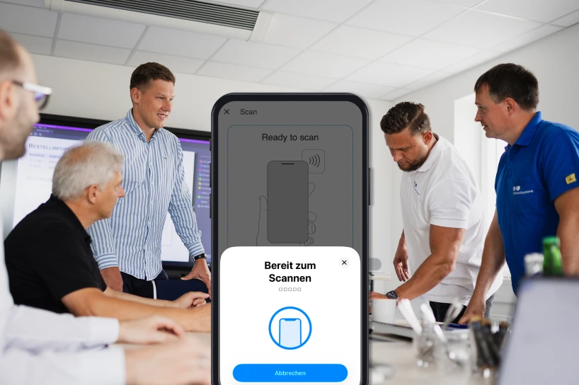 Team bespricht die NFC-Konfigurationsapp, Smartphone zeigt „Bereit zum Scannen“